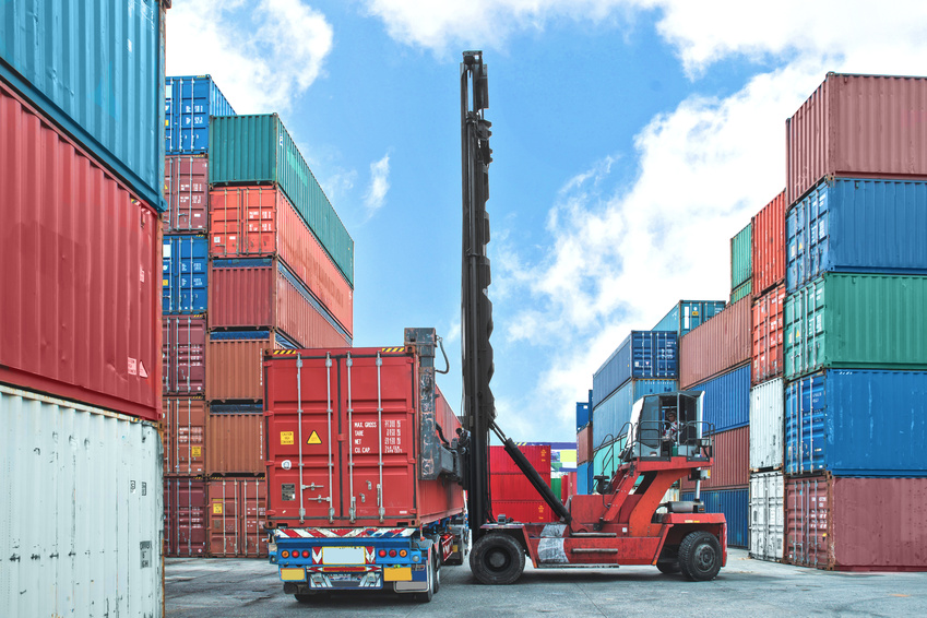 forklift handling container box loading to truck at dock