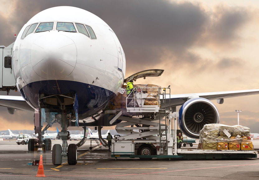 Loading cargo on the plane in airport, view through window