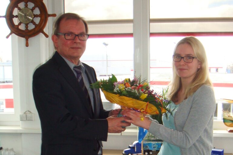 Abteilungsleiter Jürgen Finke überreicht in Namen des Hauses die Glückwünsche und den Blumenstrauß.